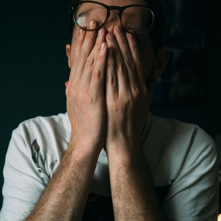 Homme se cachant le visage avec ses mains, frustré par les problèmes de son SaaS